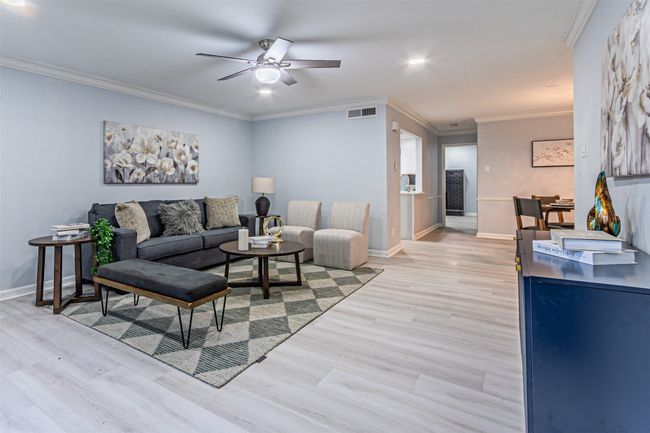 Living room featuring visible vents, crown molding, light wood-style floors, baseboards, and ceiling fan | Image 9