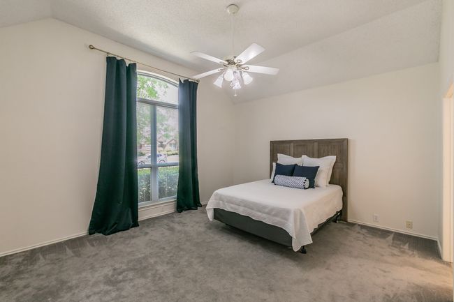 Bedroom featuring vaulted ceiling, carpet floors, and a ceiling fan | Image 27