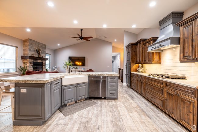Kitchen with stainless steel appliances, a stone fireplace, ceiling fan, open floor plan, and gray cabinets | Image 22