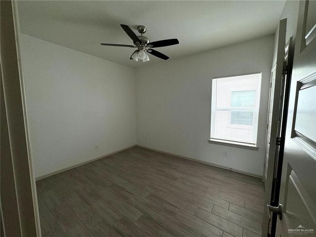 Empty room with baseboards, ceiling fan, and wood finished floors | Image 8