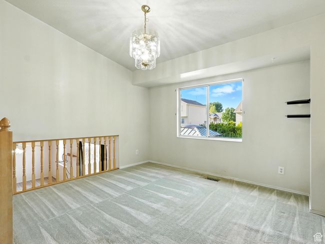 Spare room featuring carpet and a chandelier | Image 7