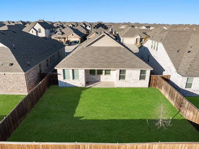 Back of house with a residential view, a patio area, brick siding, and roof with shingles | Image 26