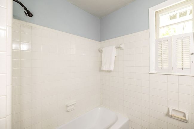 This bathroom has a tub and shower combination with tile surround. | Image 61