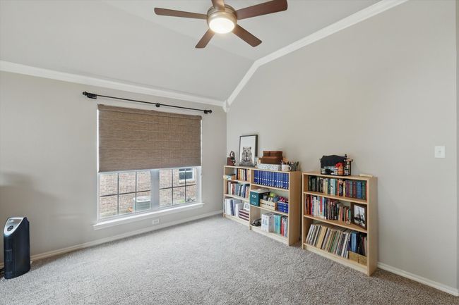 Living area featuring a ceiling fan, crown molding, baseboards, lofted ceiling, and carpet flooring | Image 8