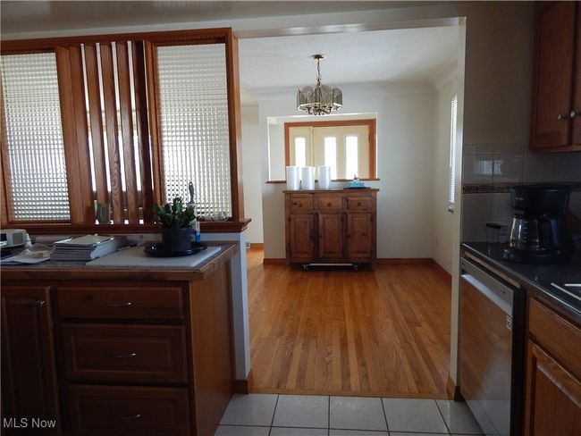 Kitchen featuring Custom designed Divider stainless steel dishwasher, an inviting chandelier, wood finished floors, and a wealth of natural light | Image 14