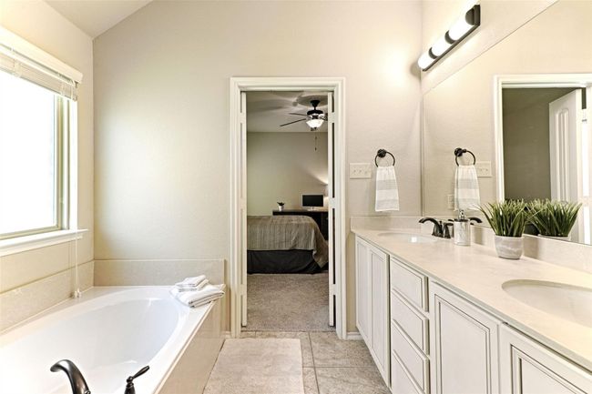 Ensuite bathroom with healthy amount of natural light, double vanity, a garden tub, and a ceiling fan | Image 15