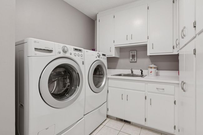 Main floor mudroom and laundry with LG front load washer and dryer, two large closets, and tons of cabinets for storage | Image 28