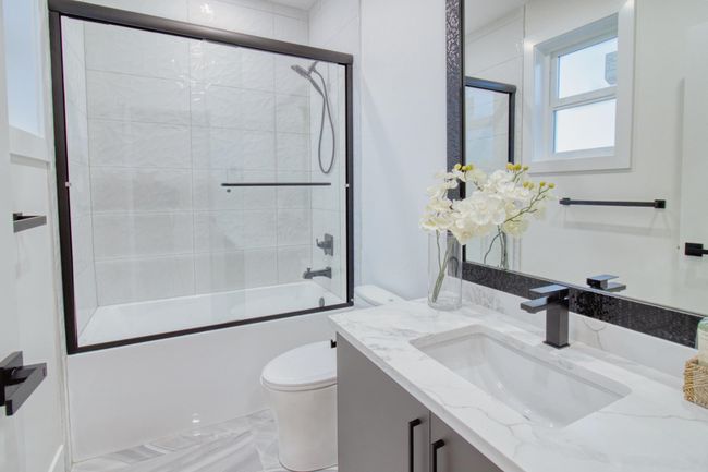 Full bathroom featuring toilet, vanity, bath / shower combo with glass door, and marble finish floors | Image 15