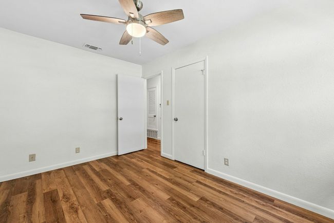 Empty room with a ceiling fan and wood finished floors | Image 17