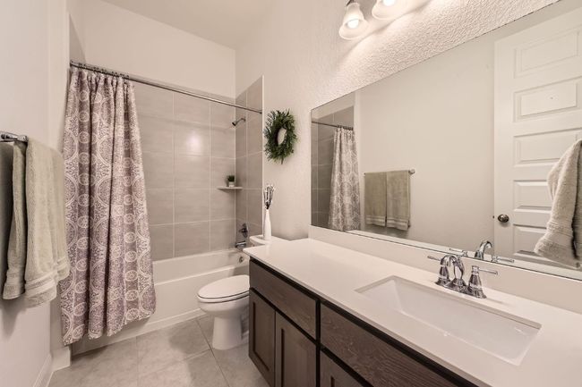 Bathroom featuring vanity, shower / bathtub combination with curtain, and tile patterned flooring | Image 20