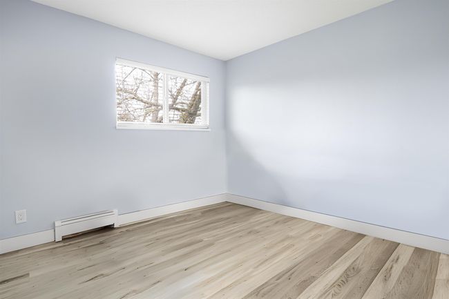 Spare room with baseboards, wood finished floors, and baseboard heating | Image 18
