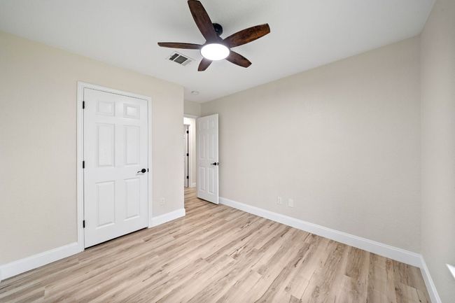 Unfurnished bedroom with light wood-style flooring and a ceiling fan | Image 21