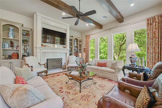 Living room featuring a ceiling fan, healthy amount of natural light, beamed ceiling, a high end fireplace, and recessed lighting | Image 16