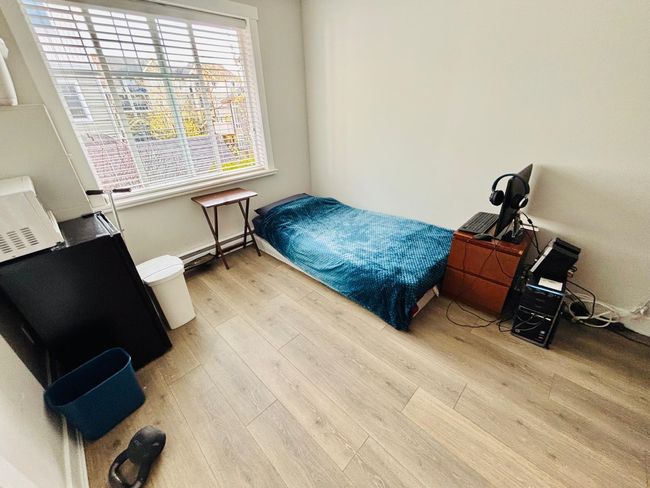 Bedroom featuring light wood-type flooring and a baseboard radiator | Image 26