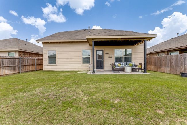 Back of house featuring a fenced backyard, a patio, and outdoor lounge area | Image 35