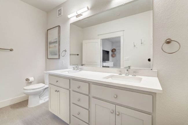 Bathroom with double vanity, toilet, and baseboards | Image 18