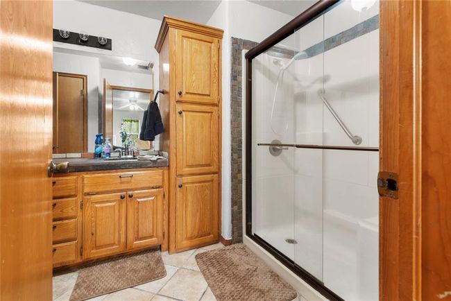 Bathroom featuring vanity, a shower stall, and tile patterned flooring | Image 23