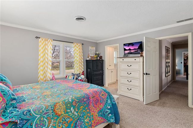 Bedroom with crown molding and light colored carpet | Image 28