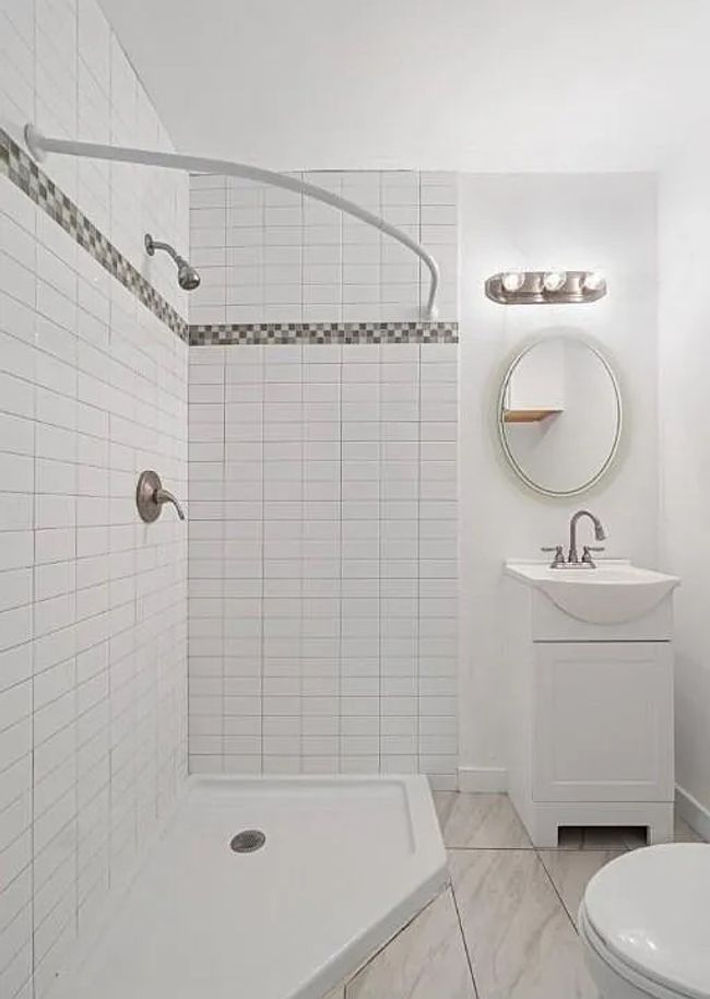 Bathroom featuring a tile shower and vanity | Image 17