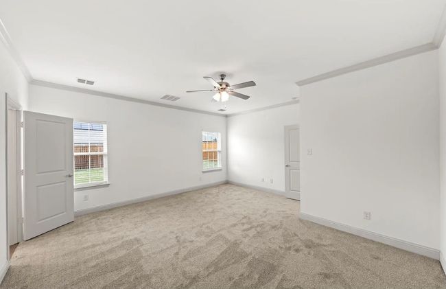 Carpeted spare room featuring crown molding, plenty of natural light, and ceiling fan | Image 11