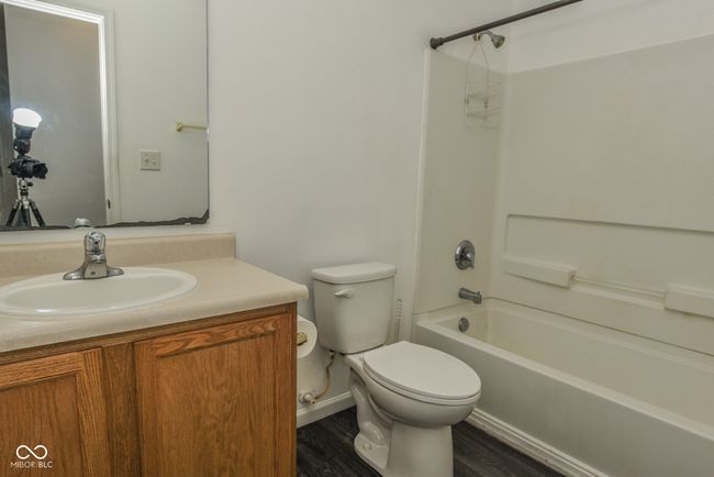 bathroom with toilet, shower combination, vanity, wood finished floors, and baseboards | Image 11