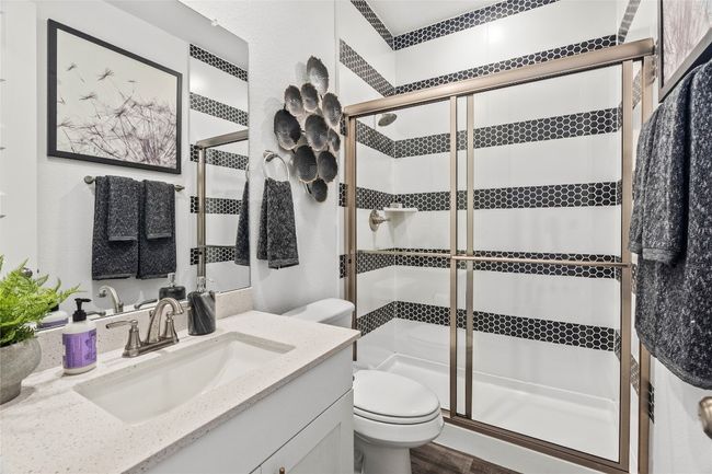 Bathroom featuring vanity, a shower stall, and wood finished floors | Image 6