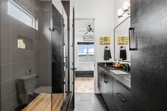 Ensuite bathroom featuring connected bathroom, vanity, a stall shower, a ceiling fan, and tile patterned flooring | Image 33