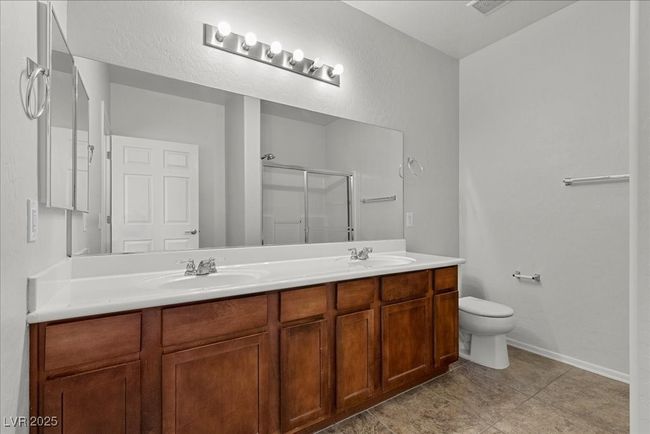Full bath featuring a stall shower, double vanity, and tile patterned floors | Image 38