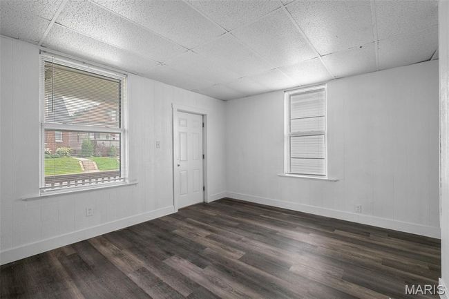 Unfurnished room with a drop ceiling and dark wood-style floors | Image 4