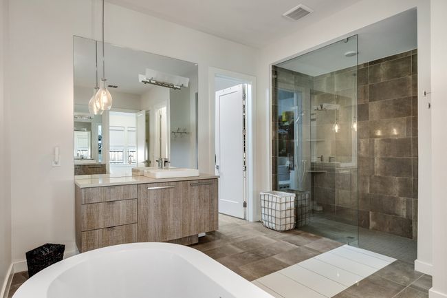 Bathroom featuring walk in shower, a freestanding bath, and vanity | Image 24