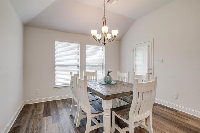 Dining space with a chandelier, lofted ceiling, wood finished floors, and baseboards | Image 17