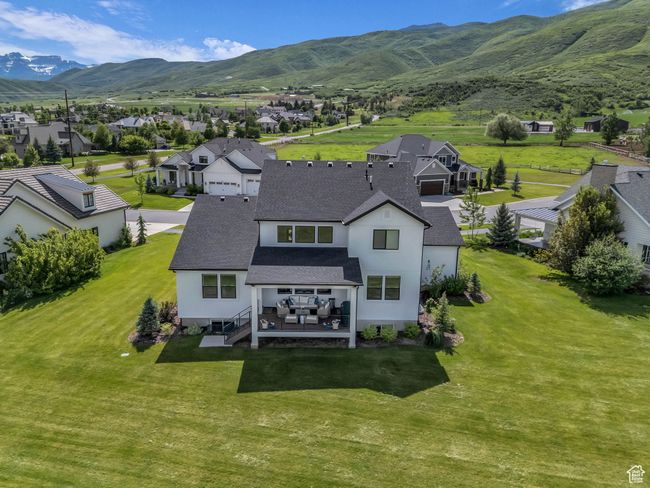 Rear view of house with roof with shingles, stucco siding, a residential view, and a lawn | Image 59