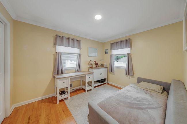 Bedroom with light wood-style floors, baseboards, and ornamental molding | Image 32