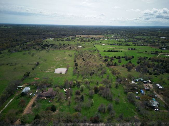 This aerial view shows the entrance L shape and the neighbors properties on each side of this land. | Image 19