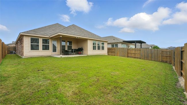 Rear view of house with a fenced backyard, a patio area, and roof with shingles | Image 36
