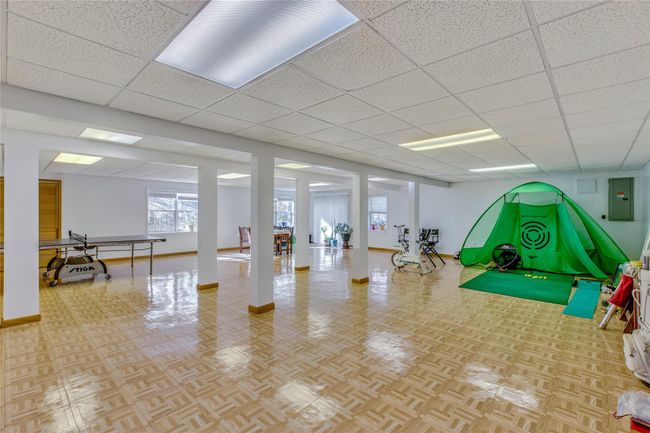 Exercise area featuring light parquet flooring, a drop ceiling, and electric panel | Image 21
