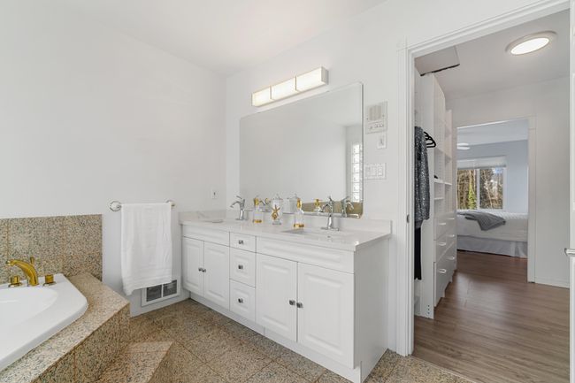 Ensuite bathroom featuring double vanity, a sink, visible vents, and connected bathroom | Image 24