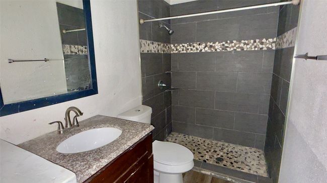 Bathroom with a tile shower and vanity | Image 26