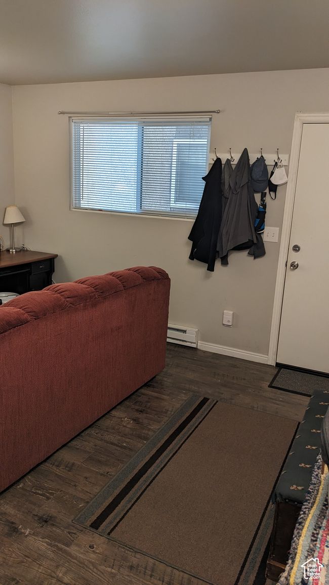 Living area with baseboard heating, wood finished floors, and baseboards | Image 7