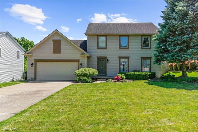 Colonial inspired home with a front lawn and a garage | Image 1