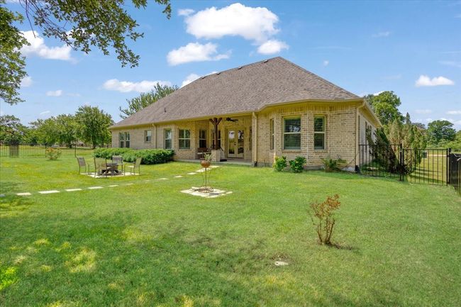 Back of house featuring an outdoor fire pit, french doors, brick siding, and roof with shingles | Image 19