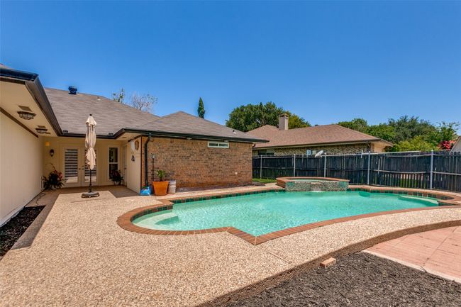 View of swimming pool with a patio area, a fenced backyard, french doors, and a pool with connected hot tub | Image 25