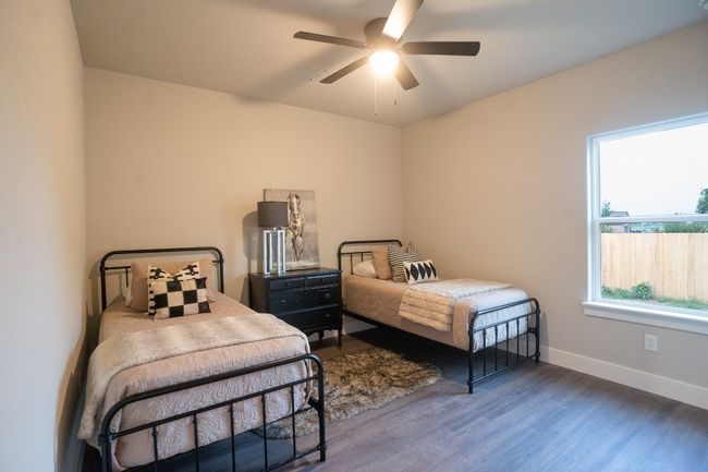 Bedroom featuring wood finished floors, baseboards, and a ceiling fan | Image 16