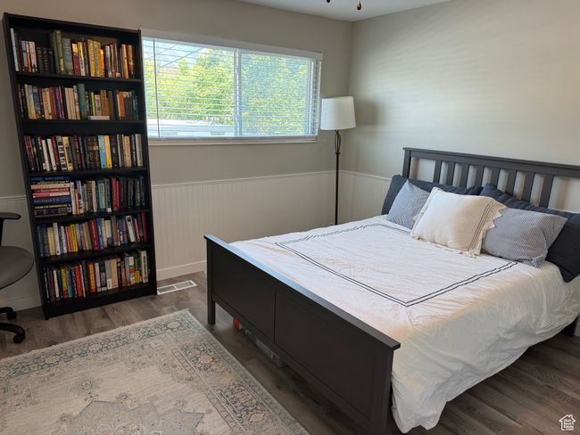 Bedroom with a wainscoted wall and wood finished floors | Image 12