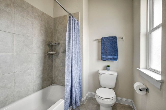 Bathroom with shower / bath combination with curtain and tile patterned floors | Image 33