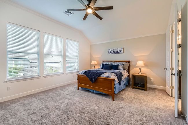 Carpeted bedroom featuring ornamental molding, vaulted ceiling, and ceiling fan | Image 15
