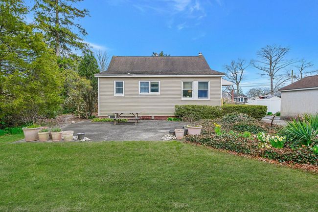 Rear view of property with a yard, a patio, and roof with shingles | Image 8