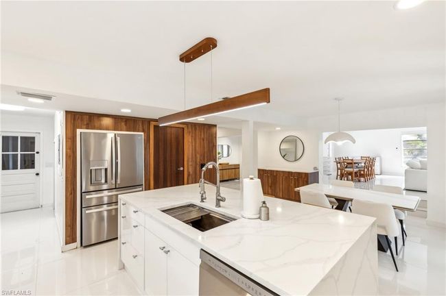 Kitchen with light stone counters, a sink, stainless steel appliances, recessed lighting, and modern cabinets | Image 6