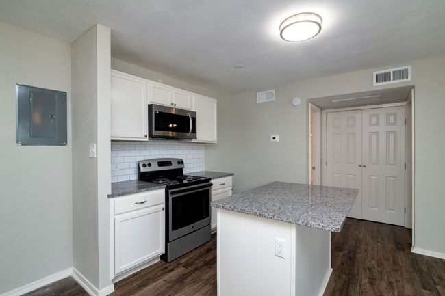 Kitchen featuring appliances with stainless steel finishes, visible vents, electric panel, and dark wood finished floors | Image 7