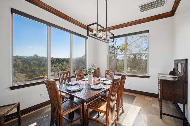 Dining space featuring an inviting chandelier, baseboards, visible vents, and ornamental molding | Image 12